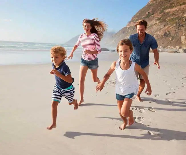 A family running on the beach with one child