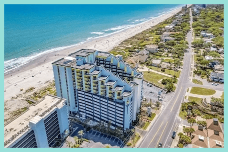 A view of the ocean from above shows an aerial view of the beach and buildings.