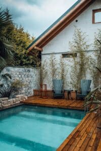 Cozy backyard pool deck with adirondack chairs and palm trees